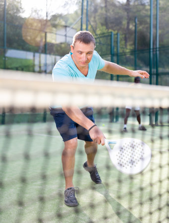European man padel tennis player trains on the courtの写真素材
