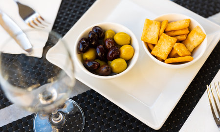Black and green olives. Crispy chips or crackers for snackの写真素材