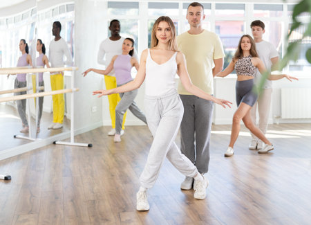 Woman with dance partner performing curtsy after rehearsal in studio