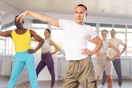 European guy with team of like-minded multinational people learn to elements of hip hop danceの写真素材