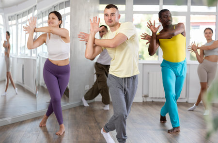 European guy with team of like-minded multinational people learn to elements of hip hop dance