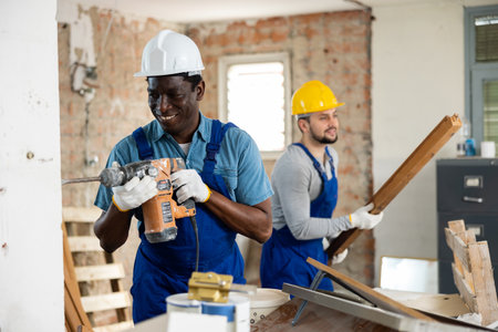 Two builders working on indoor construction siteの写真素材