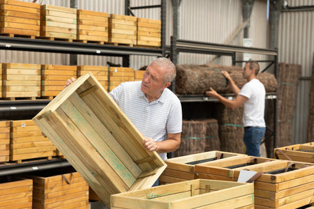 Mature male customer chooses wooden box in store.の写真素材