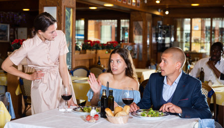 Wife scolding husband spending time with another woman in restaurantの写真素材