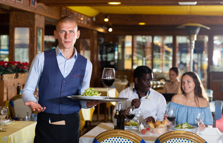 Portrait of confident waiter working at restaurantの写真素材