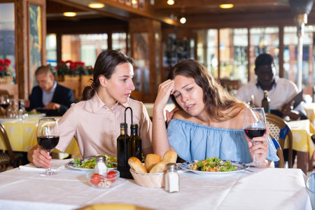 Young couple quarreling during dinner at restaurantの写真素材