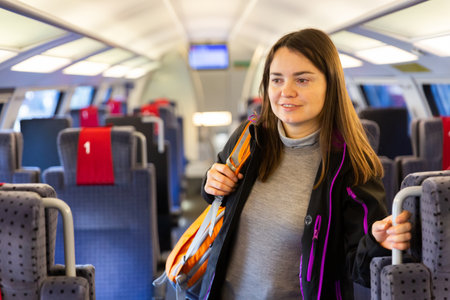 Woman standing between seats in trainの写真素材