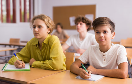 Teenage and young pupils doing tasks during lessonの写真素材
