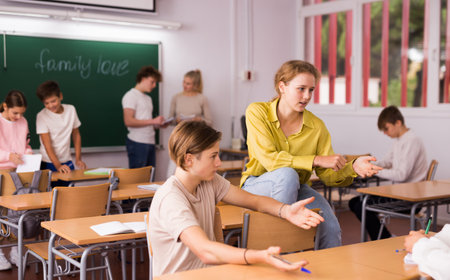 Teenage school pupils talking during break in classroomの写真素材