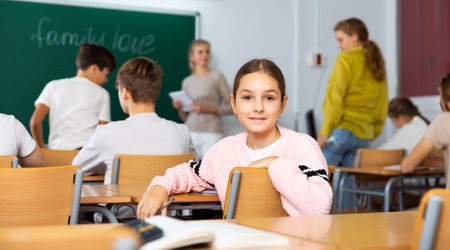 Portrait of teenage schoolgirl sitting on lesson in classroom
