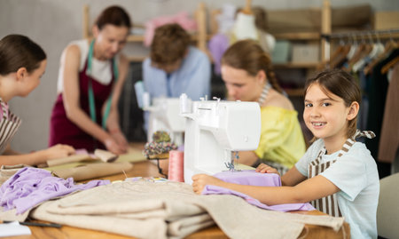 Girl child sews during practical lesson at school of young fashion designers and tailorsの写真素材