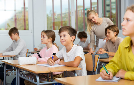 Schoolboy posing in classroom during lessonの写真素材