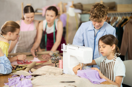 Girl child watches female classmates sew and creating clothesの写真素材