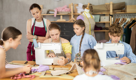 Teenage girl tries to sew surrounded by classmates, female teacher comments and help