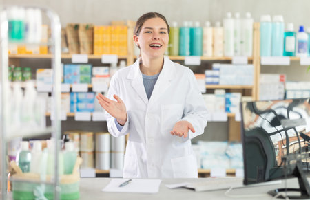 Friendly female pharmacist inviting customer to pharmacyの写真素材
