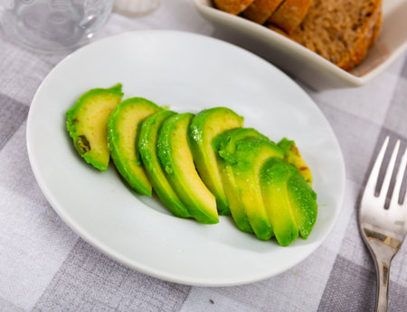 Beautifully sliced avocado with sesame seeds on a plate, serve the avocado on the festive tableの写真素材