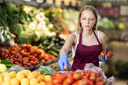 female seller lays out tomatoes on the counterの写真素材
