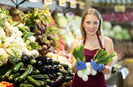 Woman seller holding shallots in her handsの写真素材