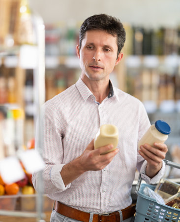 man chooses mayonnaise in the storeの写真素材