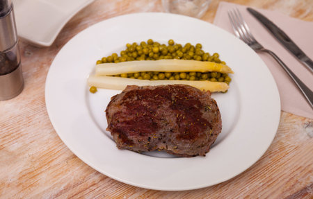 Dish of fried beef steak with green peasの写真素材