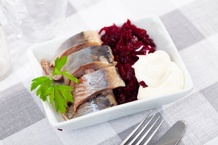 Traditional herring salad with beetroot and parsley in white plateの写真素材