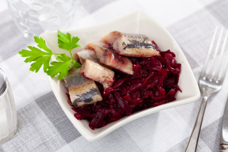 Sliced herring with grated beetroot served on tableの写真素材