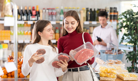 Woman with daughter chooses hamburger or entrecoteの写真素材