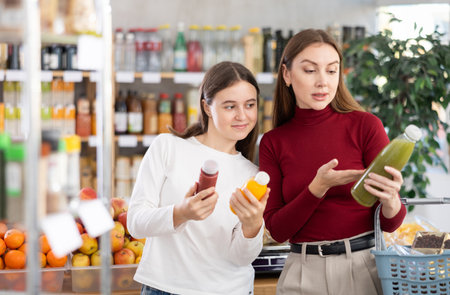 Mom and daughter choose smoothiesの写真素材