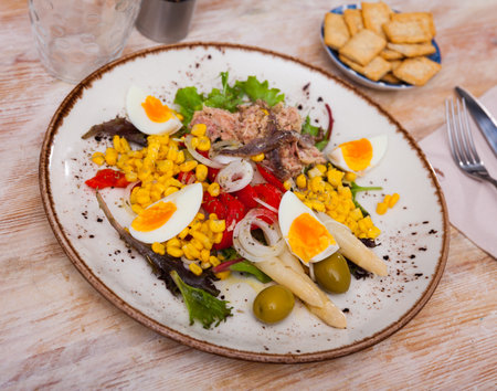 Popular dish of Spanish cuisine is the Xato salad, made from escalora, chopped salted cod, anchovies, olives, corn, onions, ..boiled eggs, red pepper and lettuce leavesの写真素材