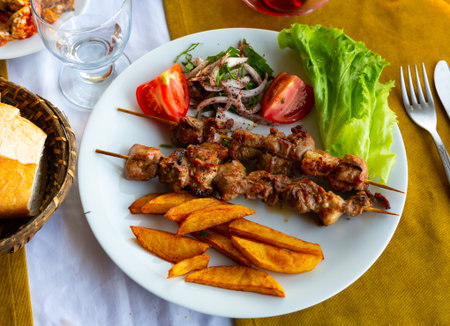 Lamb shish kebab with lettuce, tomatoes and French fries. Turkish cuisineの写真素材