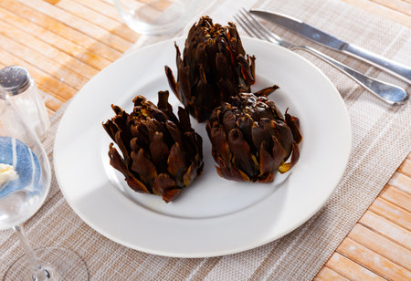 Baked artichokes with spices on plate, tasty vegetables for dinnerの写真素材