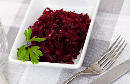 Portion of salad made of boiled and grated beetroot served on table.の写真素材