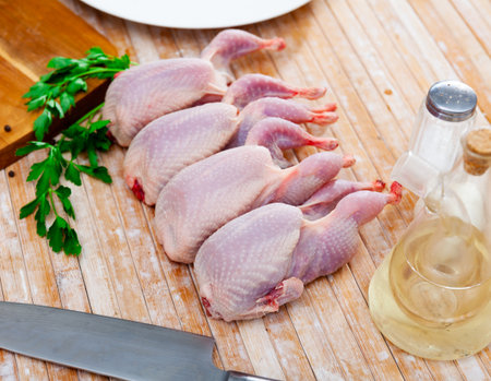 Raw quails on wooden tableの写真素材