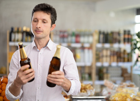 Adult man choosing beer in grocery storeの写真素材