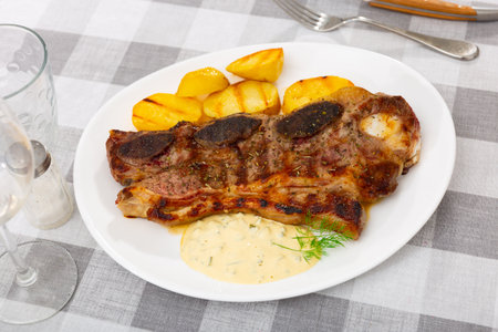 Grilled beef spare ribs with baked potatoes and sauceの写真素材