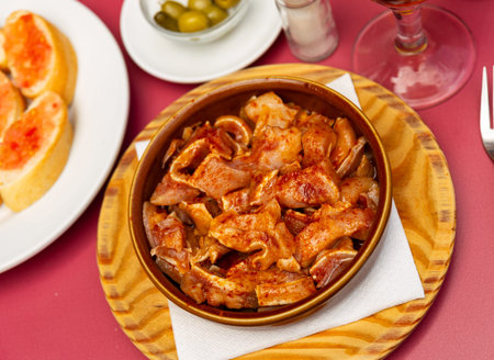 Galician dish of stewed pigs ear with red pepper and potatoes closeup