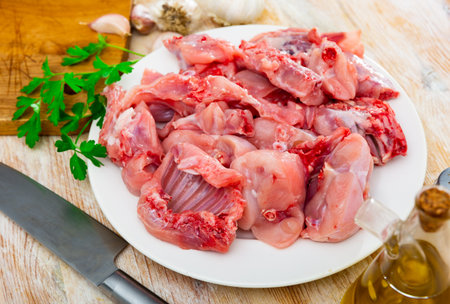 Raw sliced rabbit lying on white plate with seasonings. Dietary cooking ingredient ..の写真素材