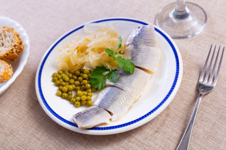 Slices of lightly salted herring filets with pickled cabbage, peas, greensの写真素材