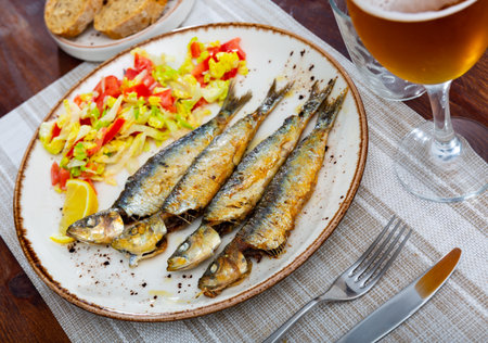 Grilled sardines served with fresh vegetable saladの写真素材