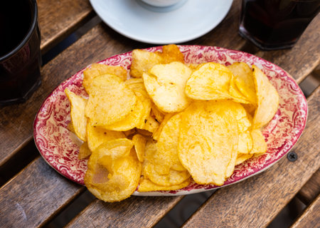 Round potato chips served in plate with a glass of vermouthの写真素材