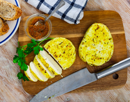 Sliced fried cottage cheese with cumin and turmeric on wooden boardの写真素材