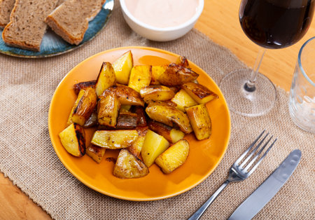 Bar serves Spanish appetizer - tapas potatoes. Slices of potatoes, toasted with peel and hot spicesの写真素材