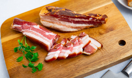 Smoked lard. Delicious pork belly with parsley on a wooden surfaceの写真素材