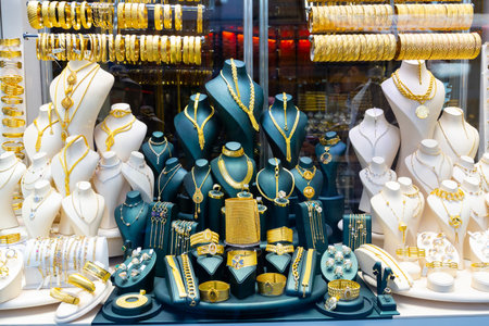 Gold jewelry at showcase of jewelry shop. Gold items in shop windows closeupの写真素材