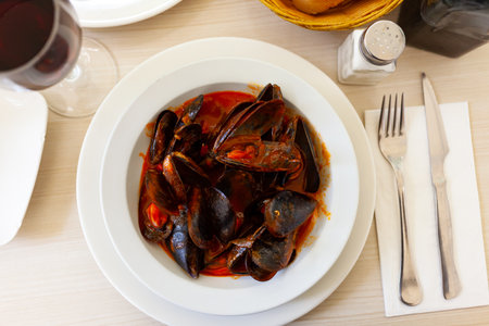Delicious boiled mussels with tomato sauce and parsleyの写真素材