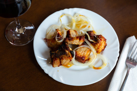 Grilled pork shashlik with fresh onion on plateの写真素材