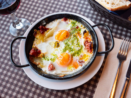 Scrambled eggs with bacon and herbs on tableの写真素材