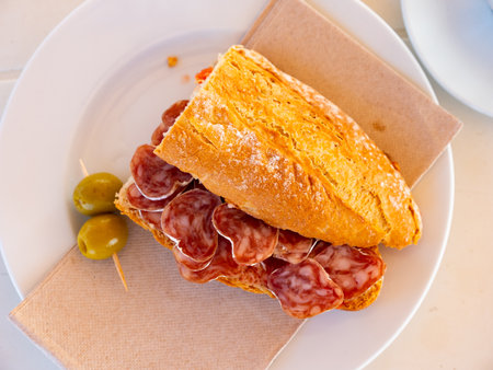 Spanish breakfast - smoked sausage fuet sandwich and olives closeupの写真素材