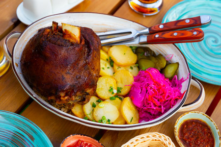German pork hock with sliced potato and marinaded foodsの写真素材