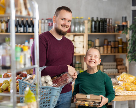 Man and his son choose groceries in a supermarketの写真素材